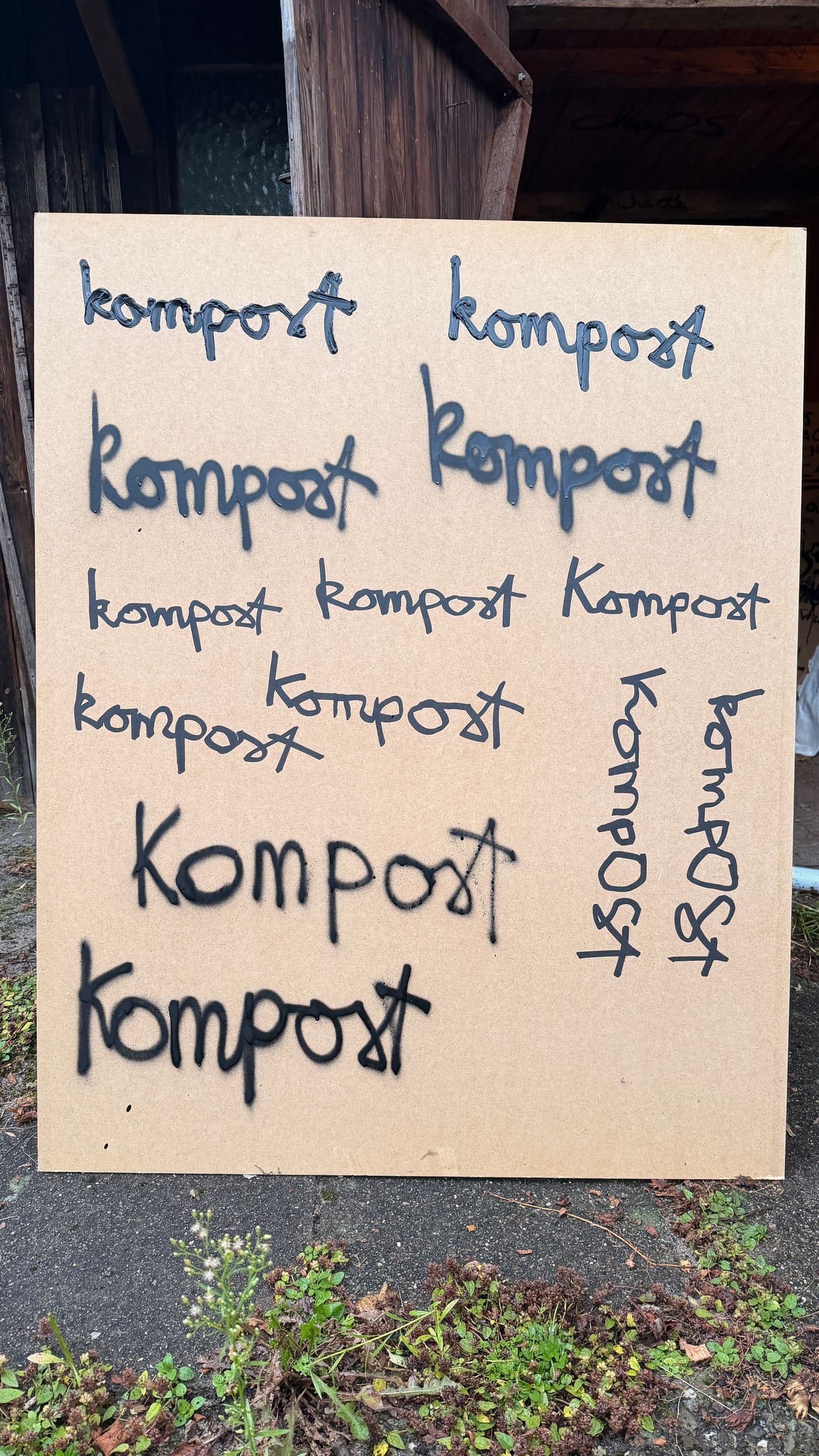 Original photo of handwritten Kompost lettering on a board outdoors